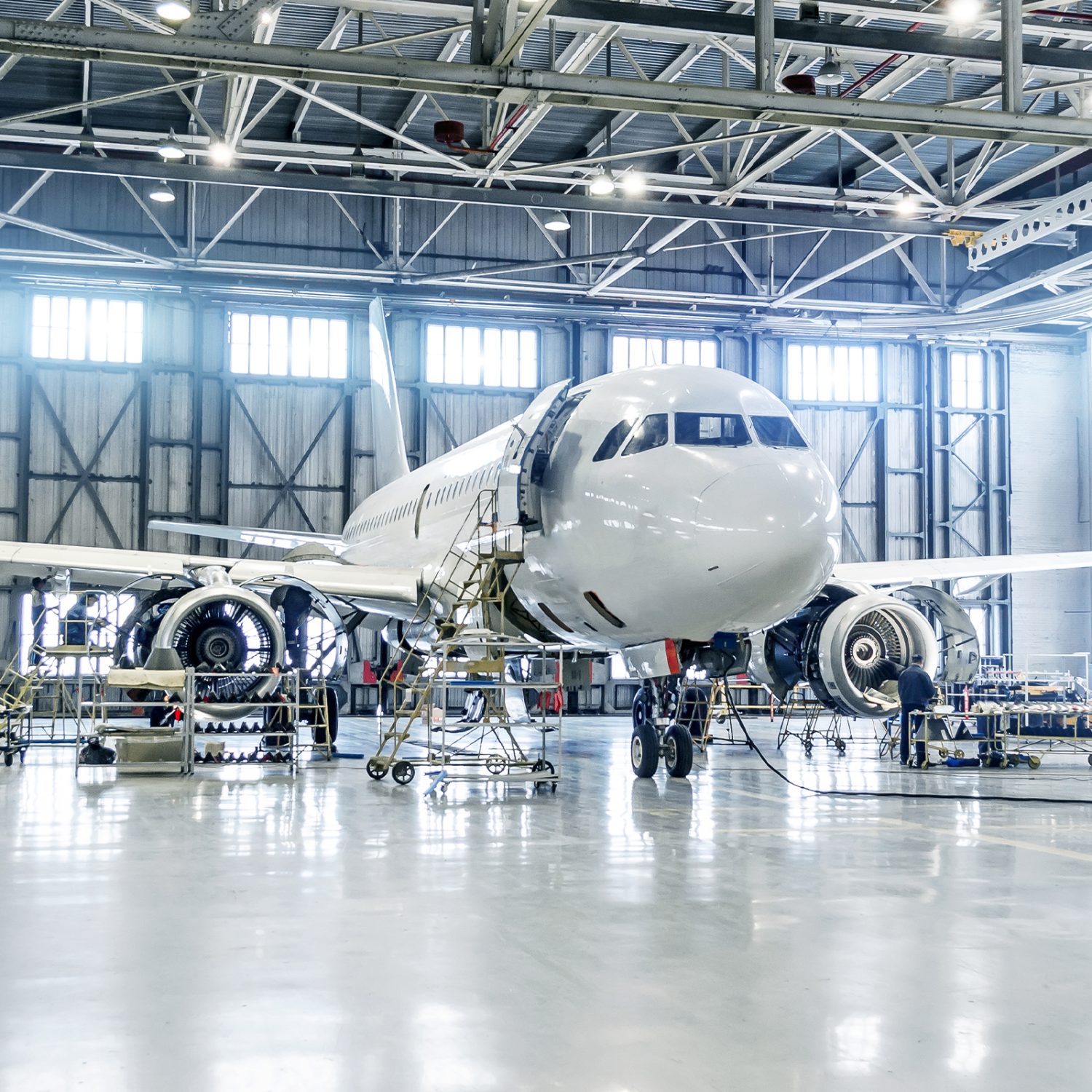 Large aeroplane in hanger, surrounded by technicians as it's worked on