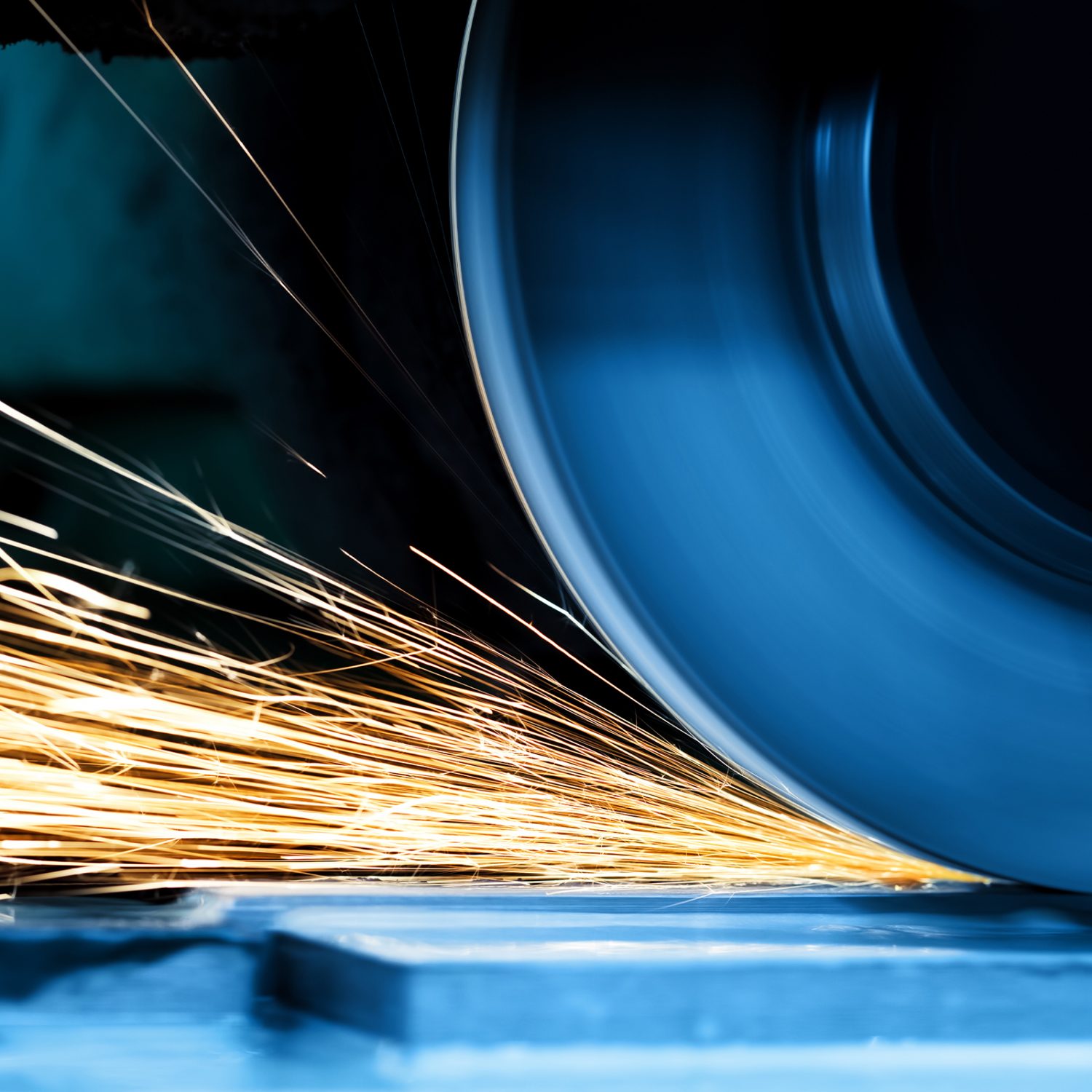 Precision grinder cutting through metal with sparks